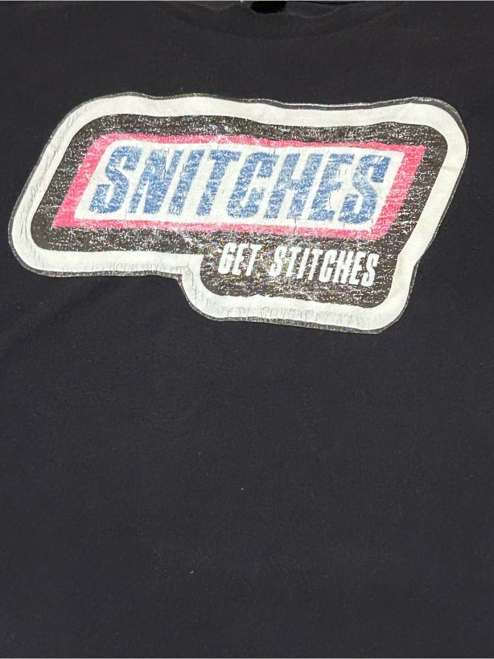 "SNITCHES Get Stitches" Graphic Tee in Black with Red & Blue Logo
